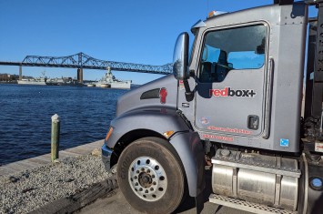 dumpster truck in front of river south boston