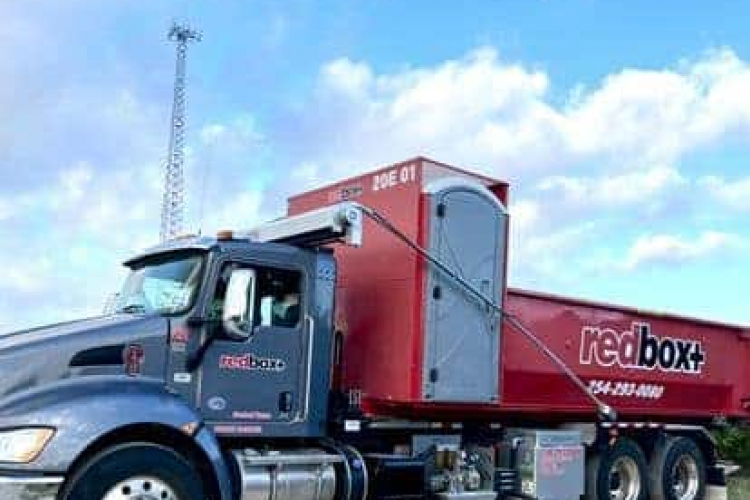 redbox+ dumpsters of central texas dumpster with porta potty in a field