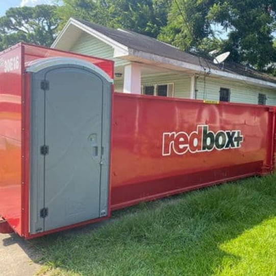 redbox+ Dumpsters of Central Texas elite dumpster rental on grass at residential jobsite