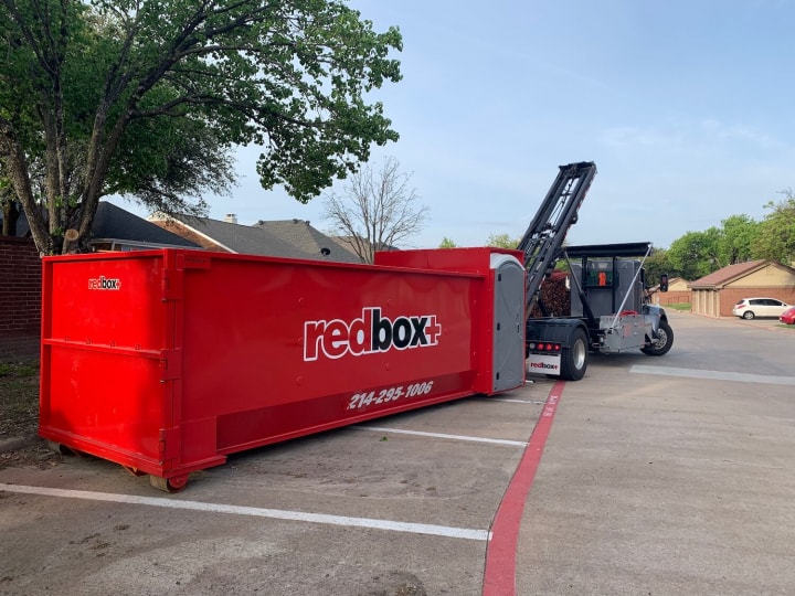 redbox+ Dumpsters of Dallas dumpster rental being dropped off at a Carrollton, TX job site