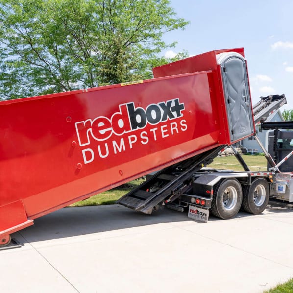 30-yard roll off dumpster rental being delivered at residential job site