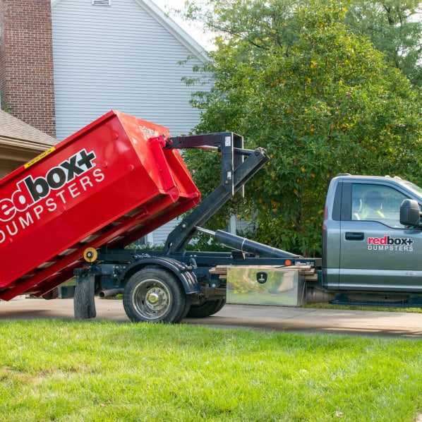 mini 10-yard dumpster being rolled off at a residential home