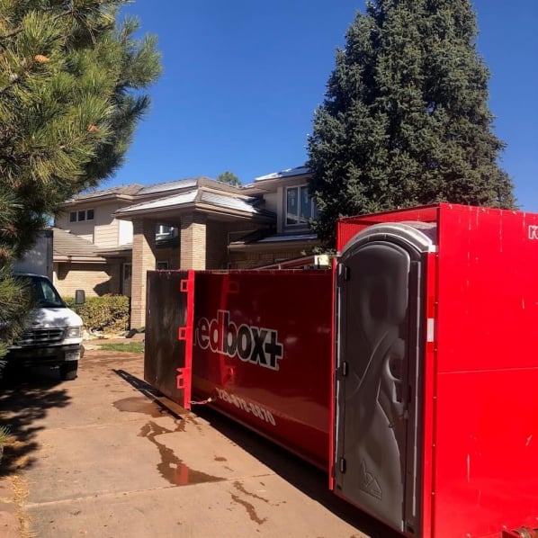 redbox+ Dumpsters of Denver South Metro Elite roll-off dumpster rental truck parked in a residential neighborhood.