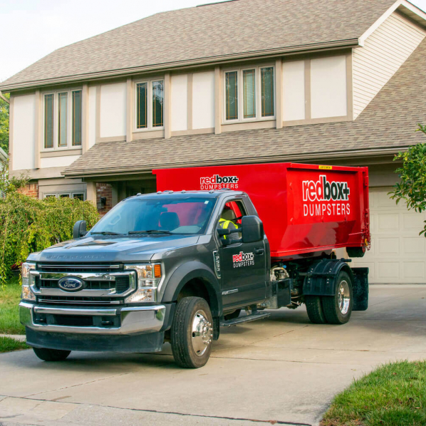 redbox+ Dumpsters of Denver South Metro mini roll-off dumpster placed on a residential driveway for home cleanup.