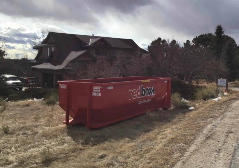 redbox+ Dumpsters of Denver South Metro roll-off dumpster placed on a rural property for a home cleanout project.