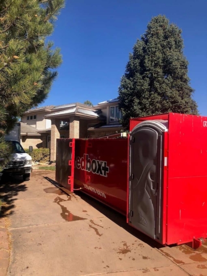 redbox+ Dumpsters of Denver South Metro Elite roll-off dumpster rental truck parked in a residential neighborhood.
