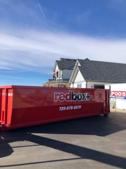 redbox+ Dumpsters of Denver South Metro roll-off dumpster placed on a residential driveway for a home renovation project