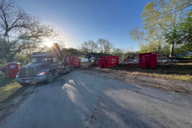 redbox+ roll-off truck and dumpsters at a construction site