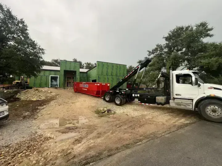 redbox+ roll-off truck delivering to a commercial construction site