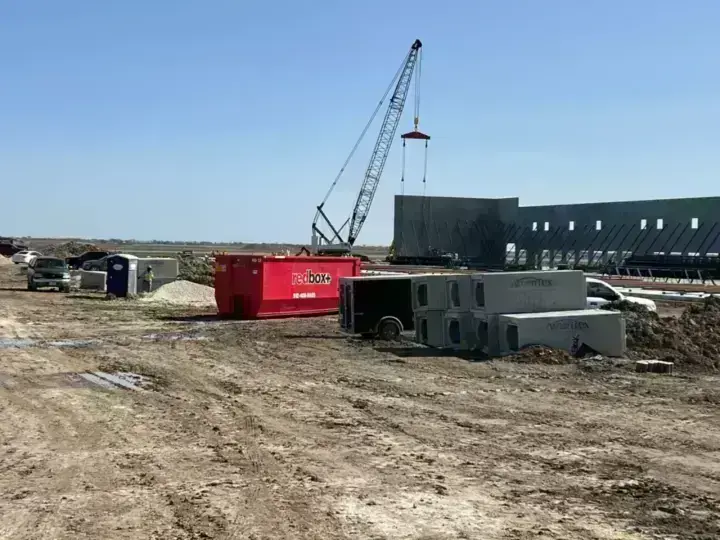 redbox+ dumpster at a commercial construction site with a crane