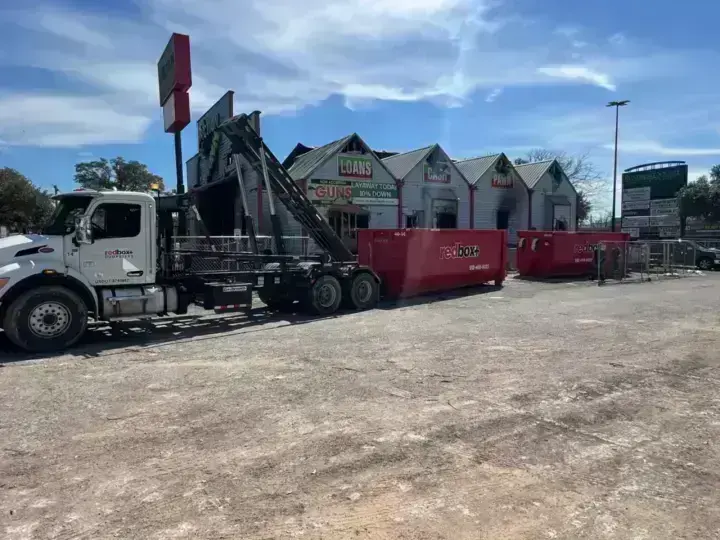 redbox+ roll-off truck at a retail construction site