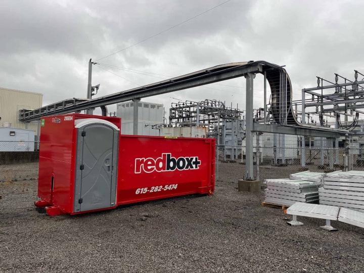 elite dumpster with porta potty at a job site in Portland, TN