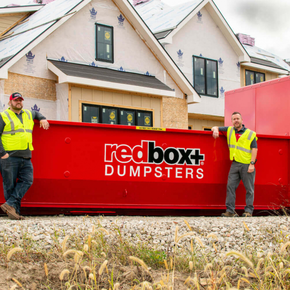 redbox+ Dumpsters of Northeast Atlanta employees standing by dumpster rental at Lawrenceville job site
