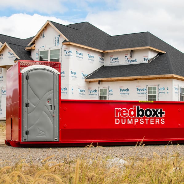 residential construction dumpster with porta potty