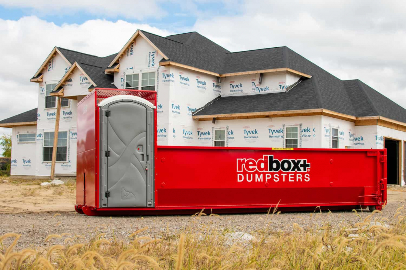 residential construction dumpster with porta potty