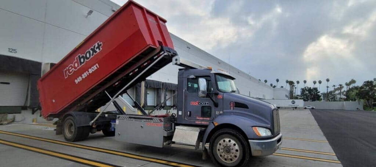 dumpster rental truck offloading dumpster in orange county