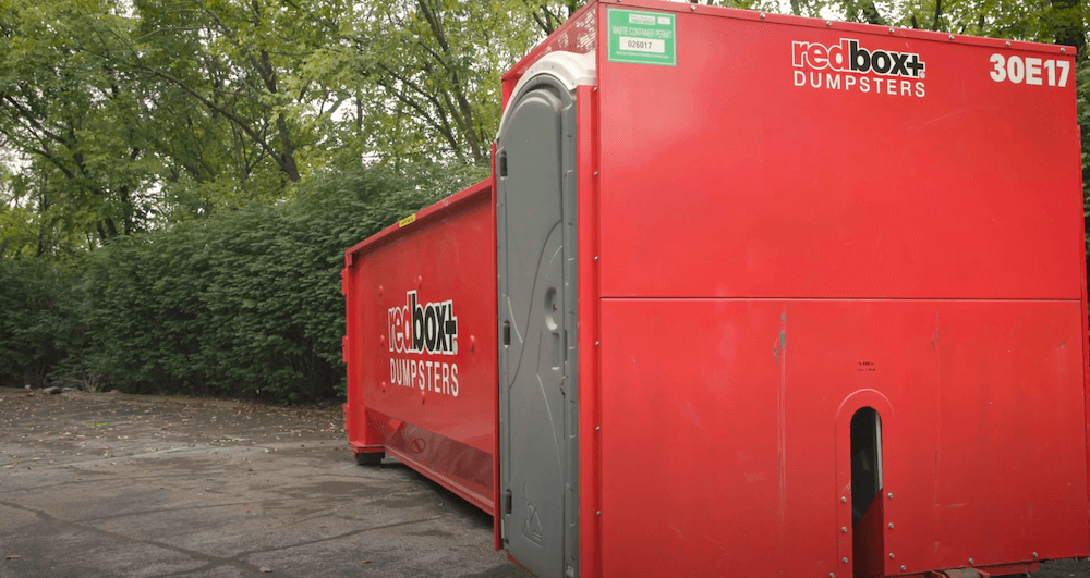 dumpster with a porta-potty at a Greenville job site