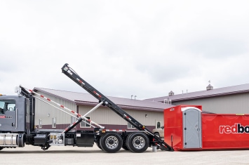 Truck pulling a redbox+ roll off dumpster