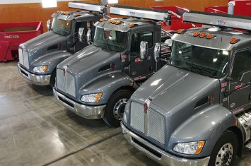 redbox+ Dumpster trucks lined up in a garage