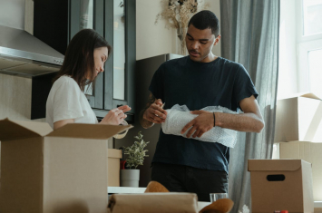 Two people cleaning items out of a home