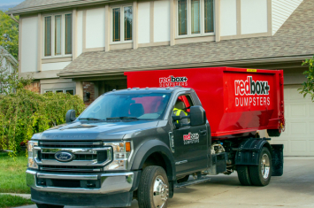 Yard Waste Roll-off Dumpster in driveway in front of a home