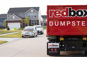 redbox+ Dumpster in front of several large homes